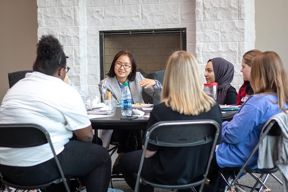 Students sit around a table during a cultural discussion event